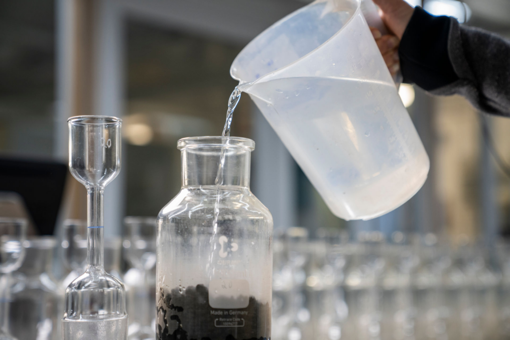 Vorbereitung einer Baustoffprobe mit Wasser im IBQ-Labor
