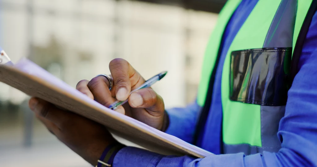 Beschäftigter dokumentiert Ergebnisse einer Gefährdungsbeurteilung auf einer Checkliste